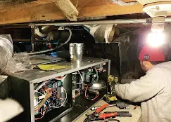 Technician installing a smart thermostat in a stylish living room, showcasing modern home technology