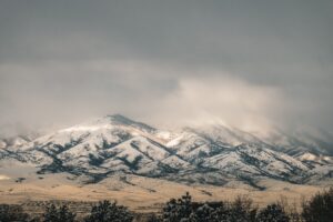 heat pump operating in snowy Utah yard with Wasatch Front in background